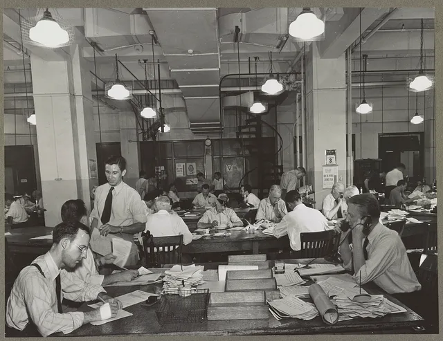 News room of the New York Times newspaper Right foreground, city editor. Two assistants, left foreground. City copy desk in middle ground, with foreign desk, to right; telegraph desk to left. Make-up desk in center back with spiral staircase leading to composing room. Copy readers go up there to che. Daily news explainers: a reporting guide