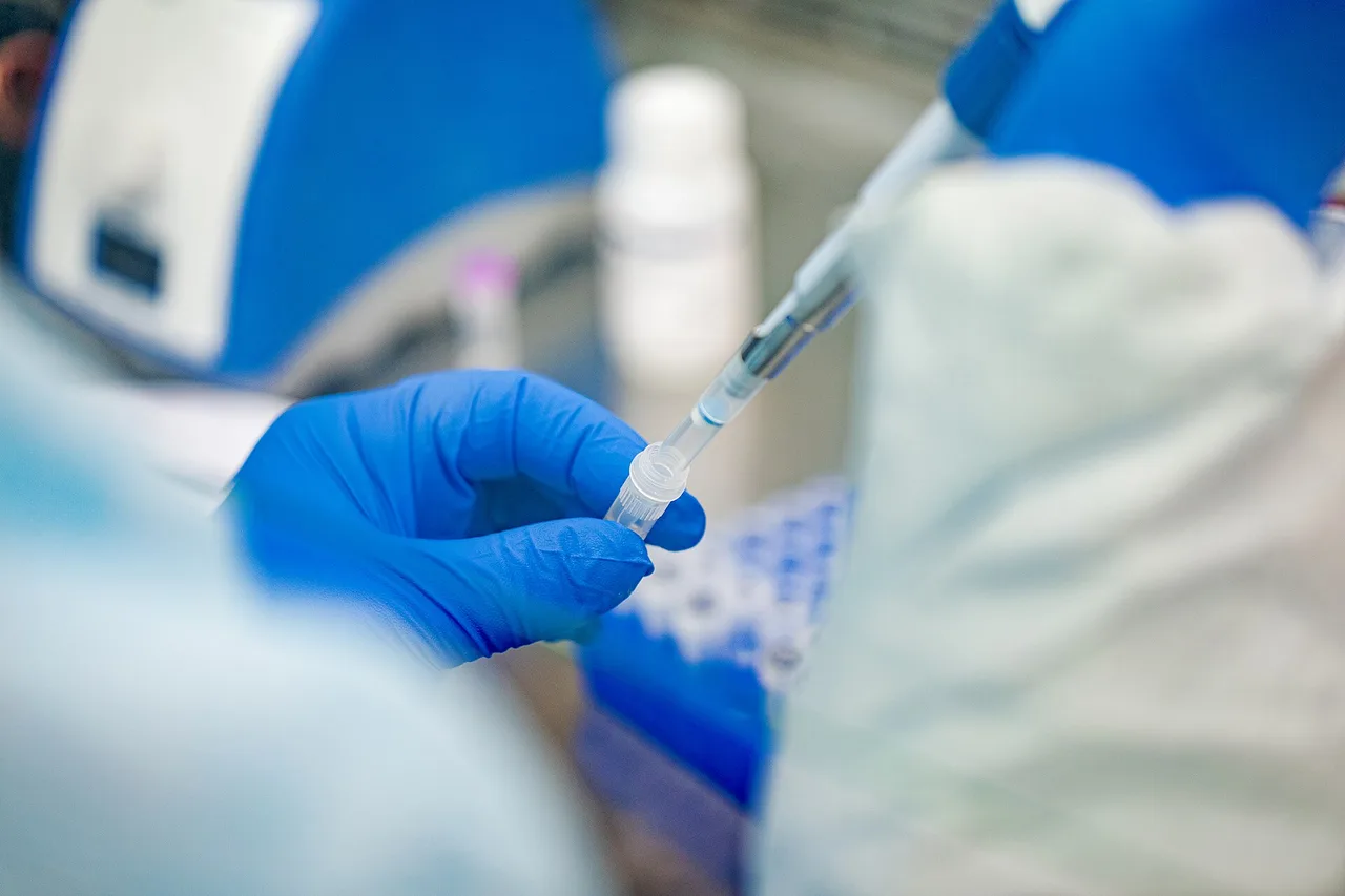 A laboratory worker handling a sample